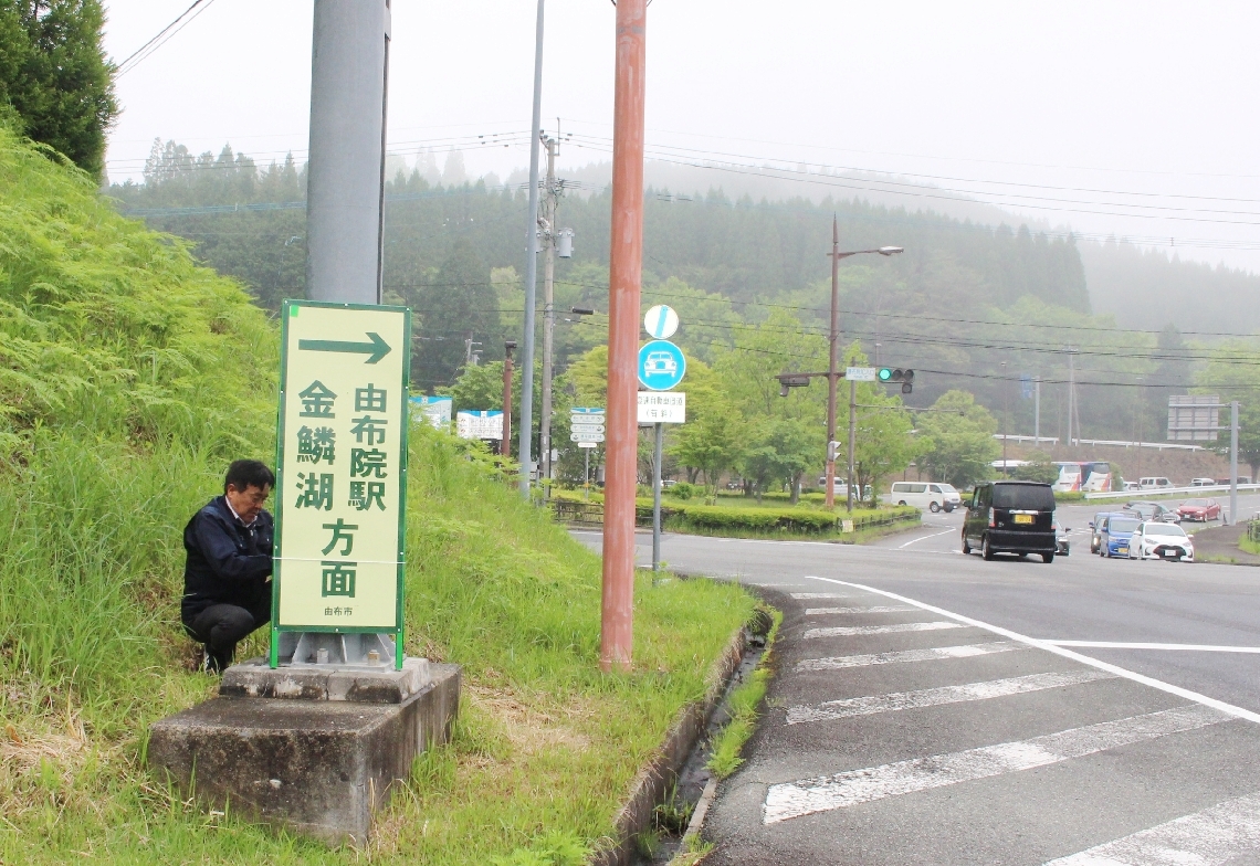 誘導用の看板を設置する市職員＝由布市湯布院町川北