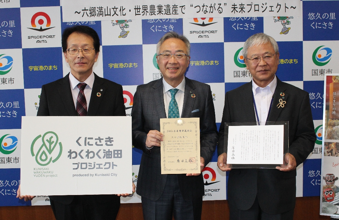 「ＳＤＧｓ未来都市」に選ばれたことを喜ぶ松井督治国東市長（中央）＝国東市役所
