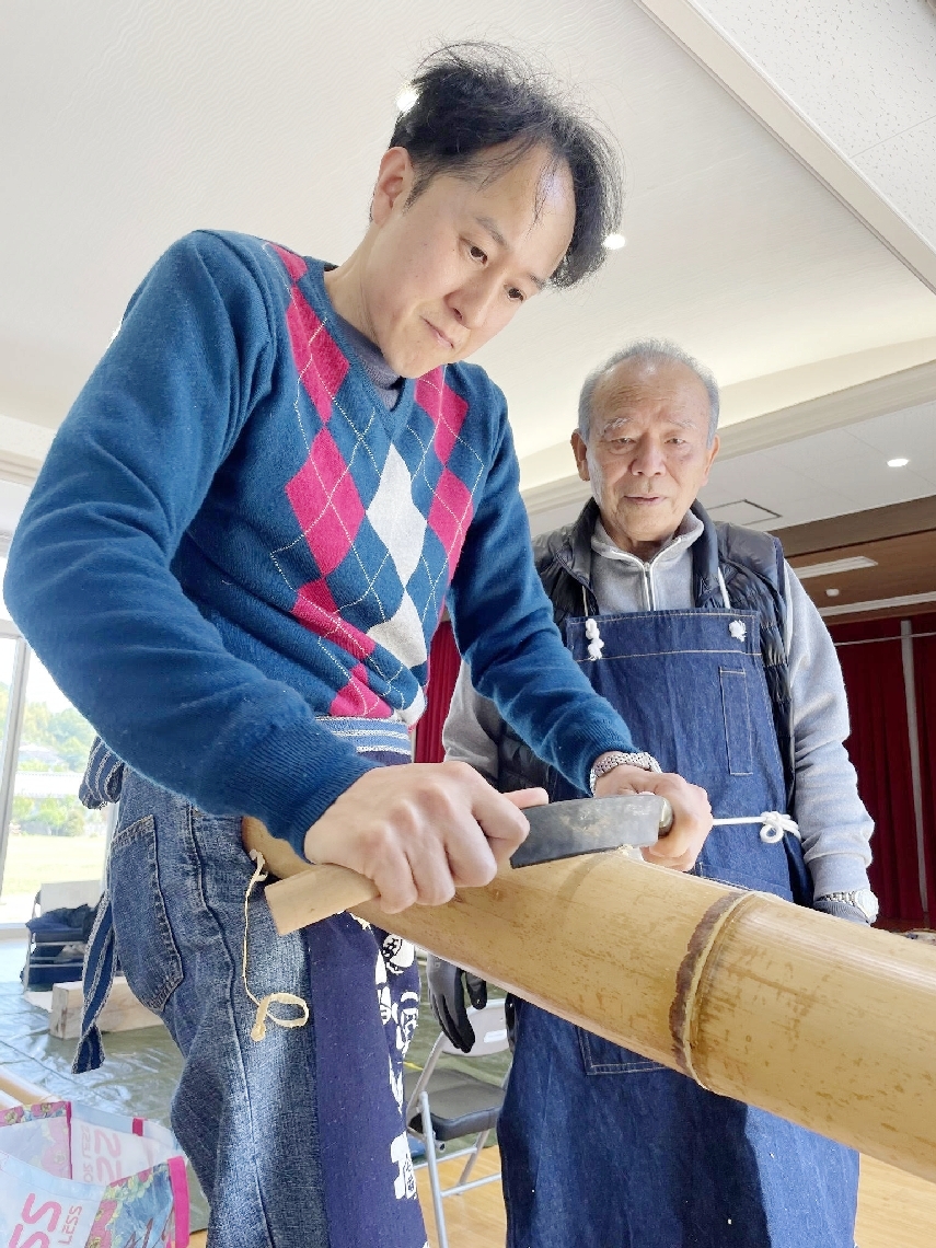 竹磨きの手本を示す中岩孝二さん＝大分市の竹中公民館