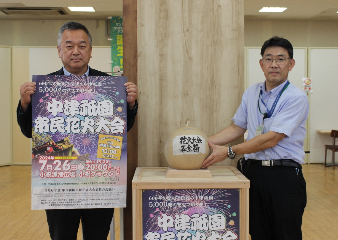 一尺玉花火の募金箱（中央）を置いて募金を呼びかける実行委の細川唯副委員長（左）ら＝中津市豊田町のサンリブ中津