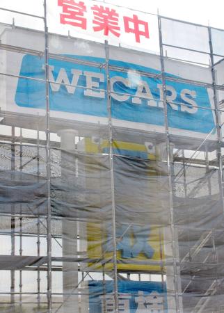 かけ替え工事が進む「ＷＥＣＡＲＳ（ウィーカーズ）」が設置した新会社名の看板＝２４日午前、東京都多摩市
