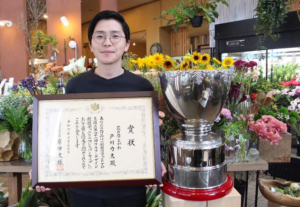 花の店とがわの社長を務める戸川力太さん。念願のジャパンカップを手に「花で語る人になりたい」＝大分市牧