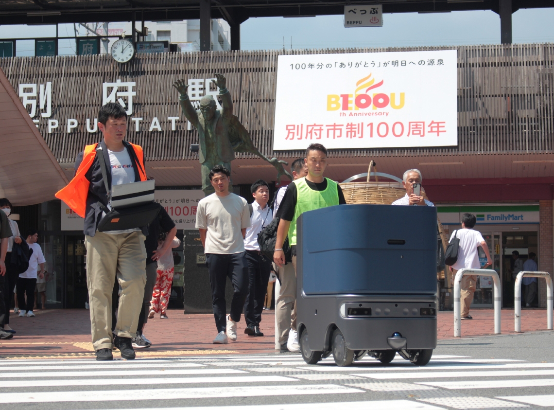 公道を進む自動配送ロボット「ハコベース」＝別府市のＪＲ別府駅東口