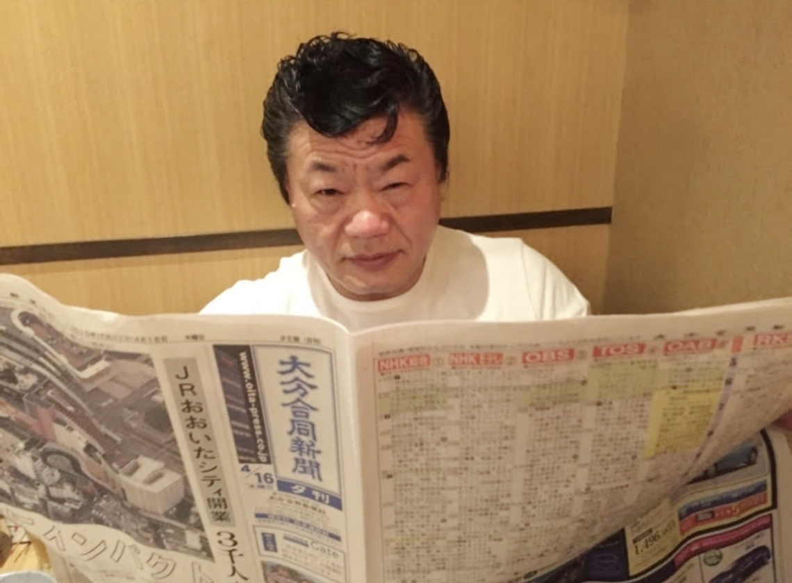 大分合同新聞を広げる小林邦昭さん＝２０１５年