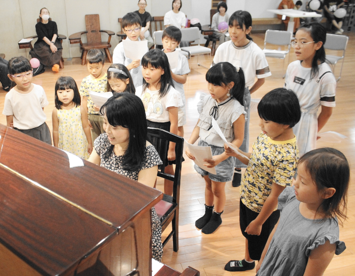 大塚亜依さんの指導を受けながら、練習する竹田市ひばり少年少女合唱団の子どもら＝竹田市竹田町
