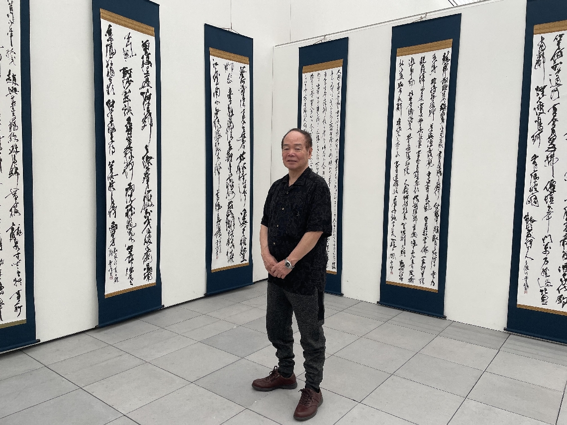 個展コーナーで写真に納まる水田雲峰さん