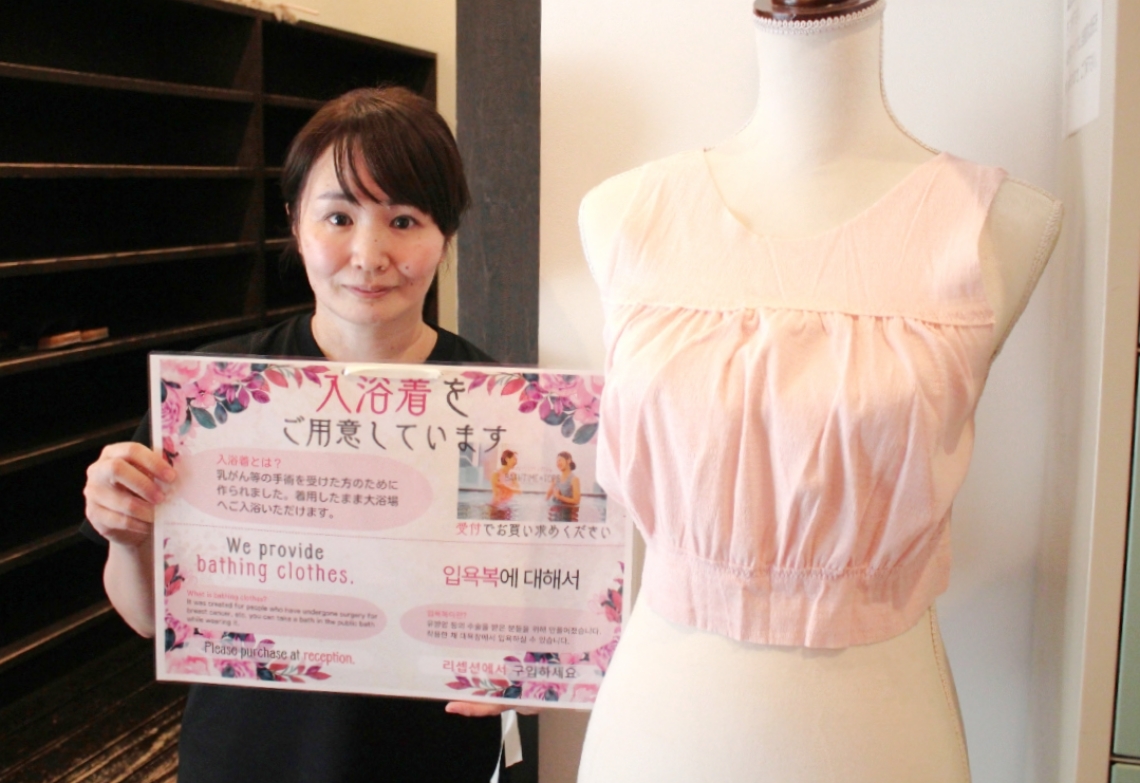 手作りポスターなどを掲示し、入浴着への理解を求める村上加菜子さん＝別府市鉄輪のひょうたん温泉