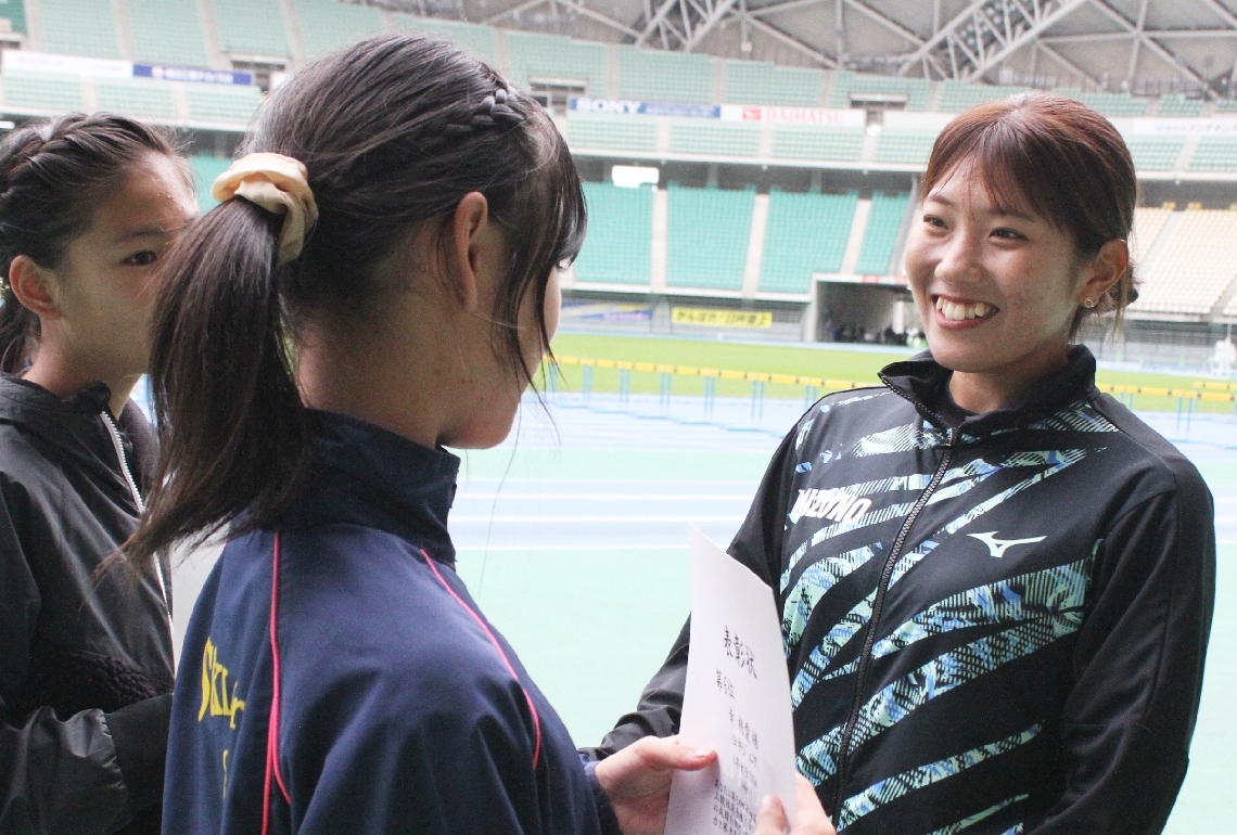 小学生の大会で入賞した選手をたたえる児玉（右）＝レゾナックドーム大分