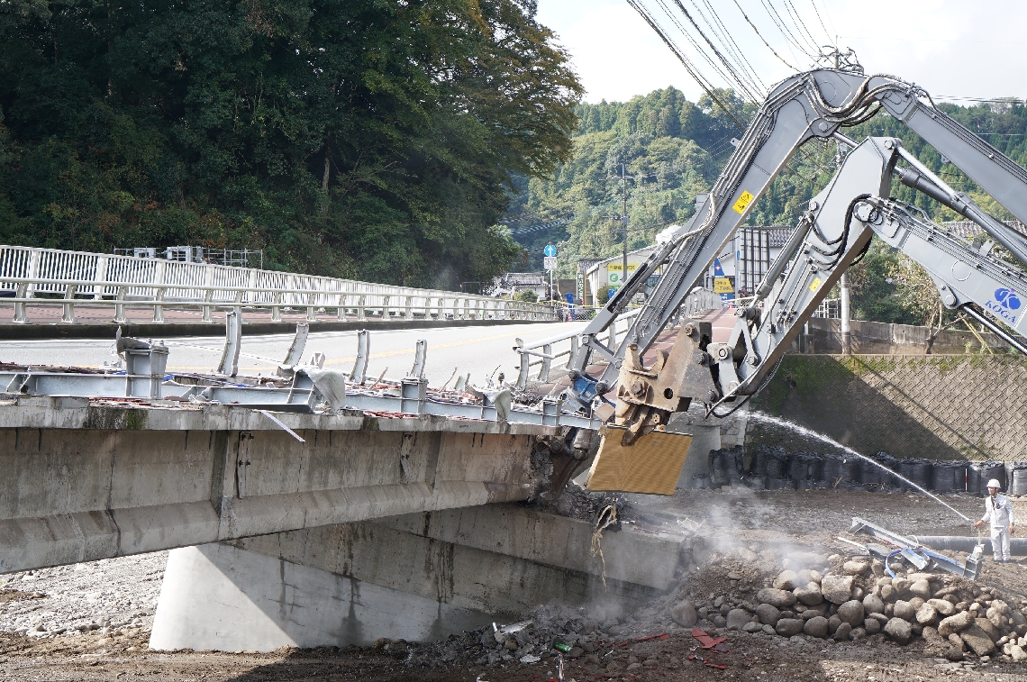 重機を使って傾いた橋の解体工事に着手＝１１日午後、日田市友田の三郎丸橋