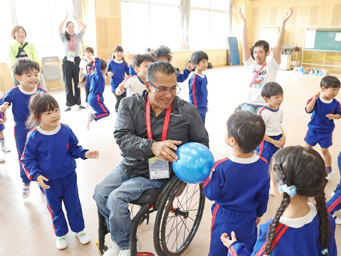 園児たちとボールを使ったゲームで遊ぶ海外選手＝１４日、大分市千代町の千代町幼稚園