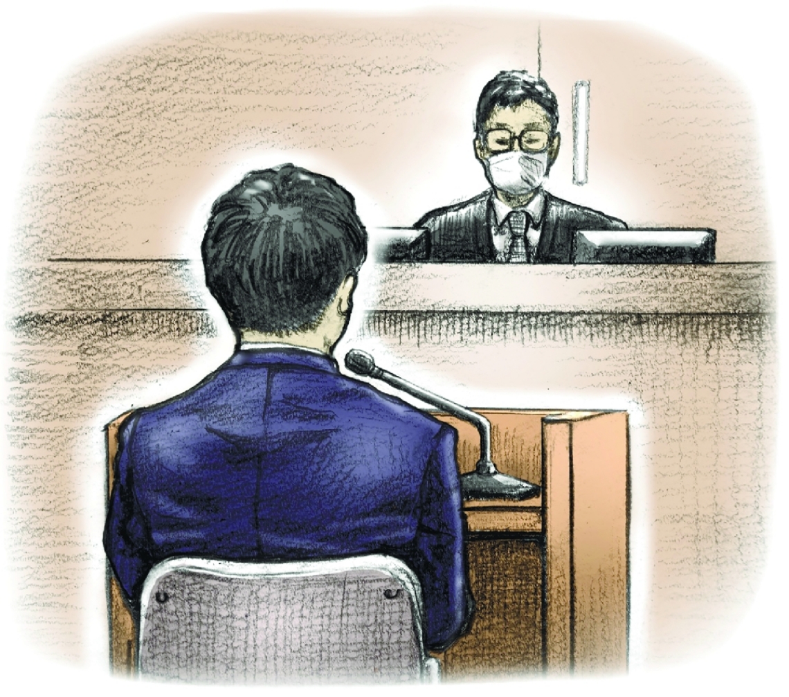 判決の言い渡しを聞く被告の男。右は辛島靖崇裁判長