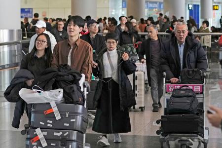 日本からの便で北京首都国際空港に到着した乗客ら＝３０日（共同）