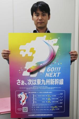 東九州新幹線のポスターを持つ大分県の職員＝１０月、大分市
