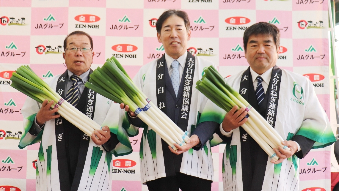 白ネギの旬入りをＰＲする大分白ねぎ連絡協議会の和泉陣会長（中央）ら＝１０日、大分市豊海