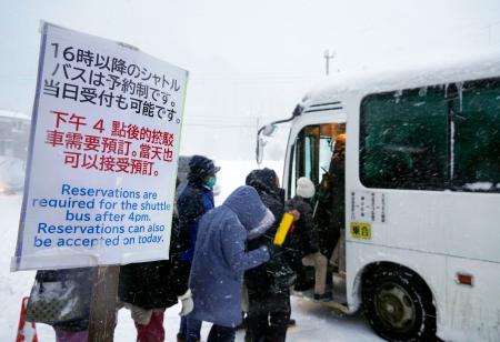 銀山温泉に向かう予約制の有料シャトルバスに乗り込む観光客＝２３日午後、山形県尾花沢市