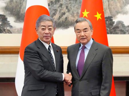 中国の王毅外相（右）と握手する岩屋外相＝２５日、北京の釣魚台迎賓館（代表撮影・共同）