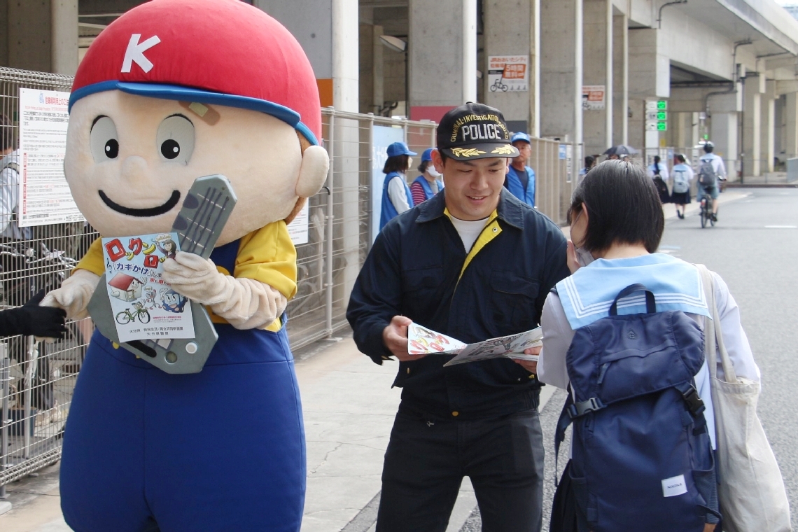 街頭活動で鍵かけの大切さを呼びかける警察官＝６月、大分市