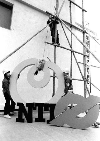 新しい看板（左）を取り付ける作業員ら＝１９８５年３月２９日、東京・向島電話局
