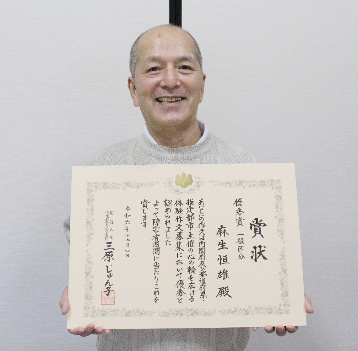 「心の輪を広げる体験作文」で優秀賞を受賞した麻生恒雄さん＝津久見市上宮本町