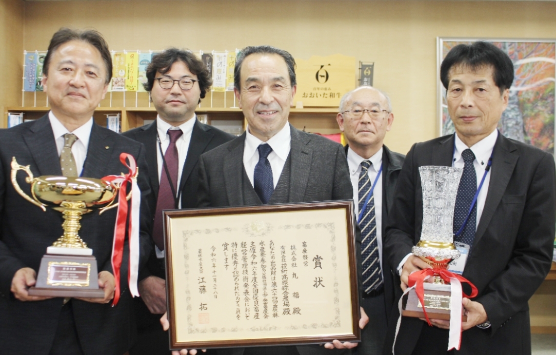 農林水産大臣賞に輝いた丸福、荻町高原綜合農場の工藤厚憲社長（中央）＝昨年１２月、県庁