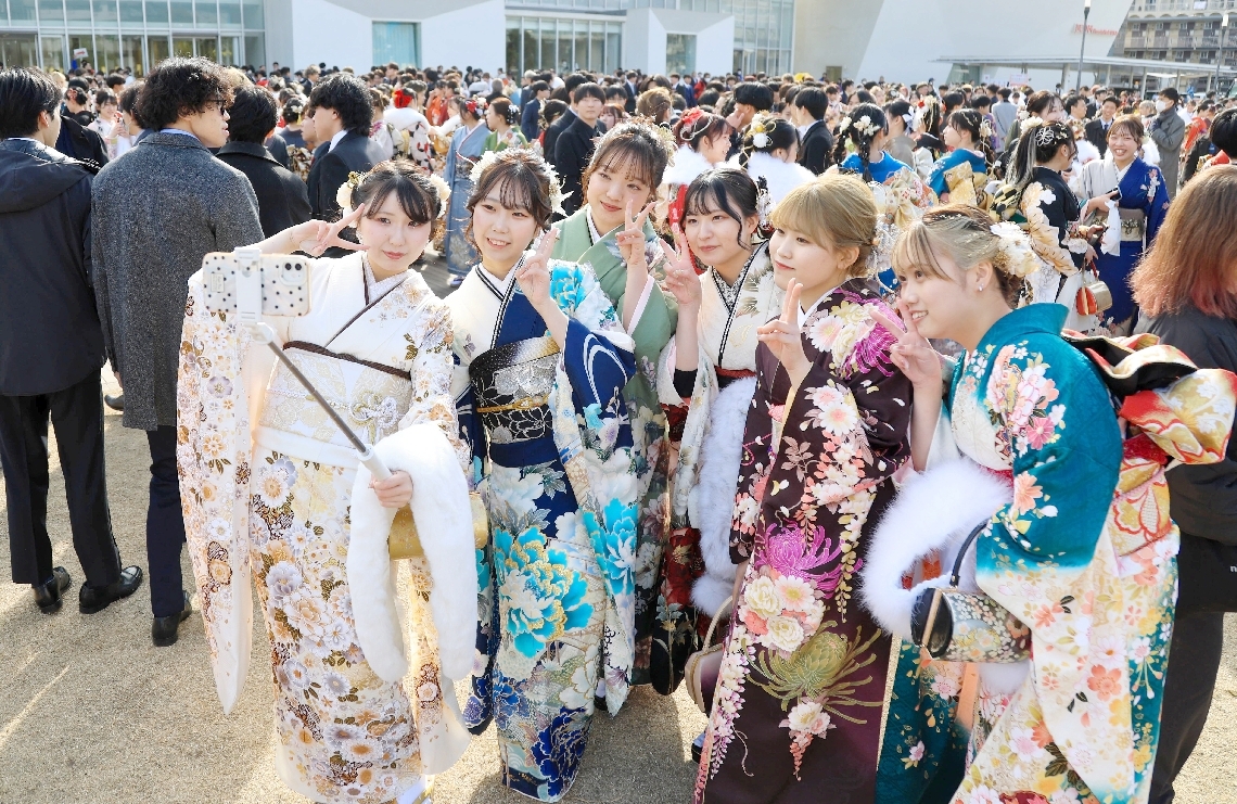 華やかな晴れ着姿で記念撮影をする参加者＝１２日、大分市東大道の大分いこいの道広場