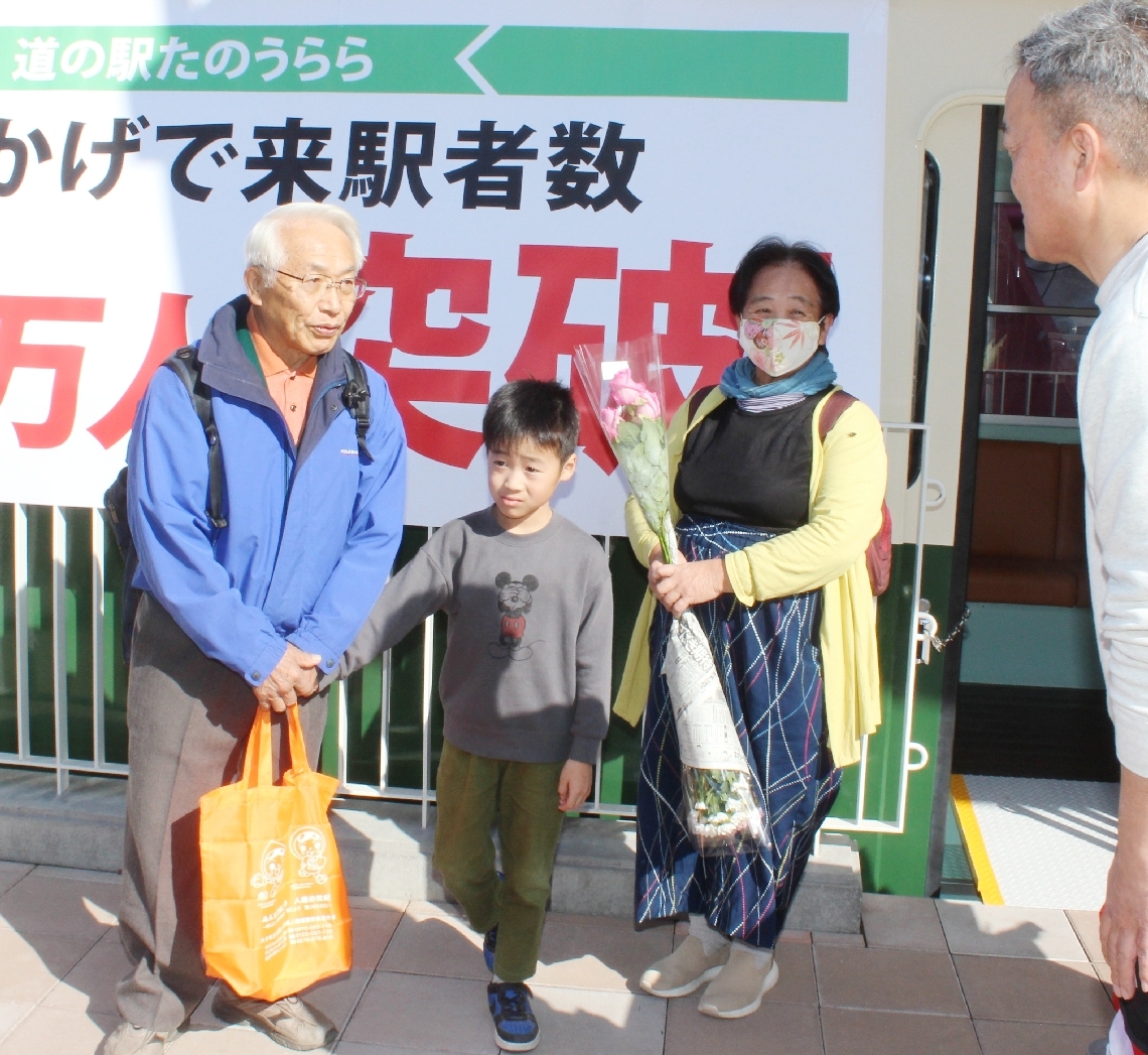 関係者（右）の祝福を受ける植木さん夫婦と孫の江藤司樹さん＝２５日、大分市神崎