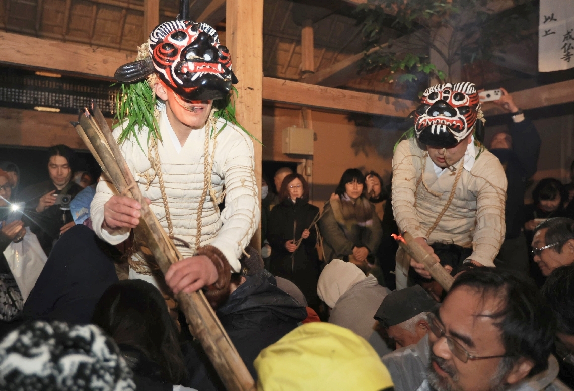 健康を祈願する参拝者の肩などをたたいて回る鬼＝１日夜、国東市国東町の岩戸寺
