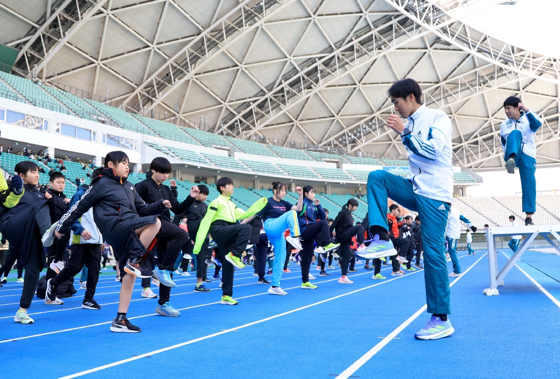 参加した子どもたちにストレッチなどを教える青山学院大の選手（右手前）