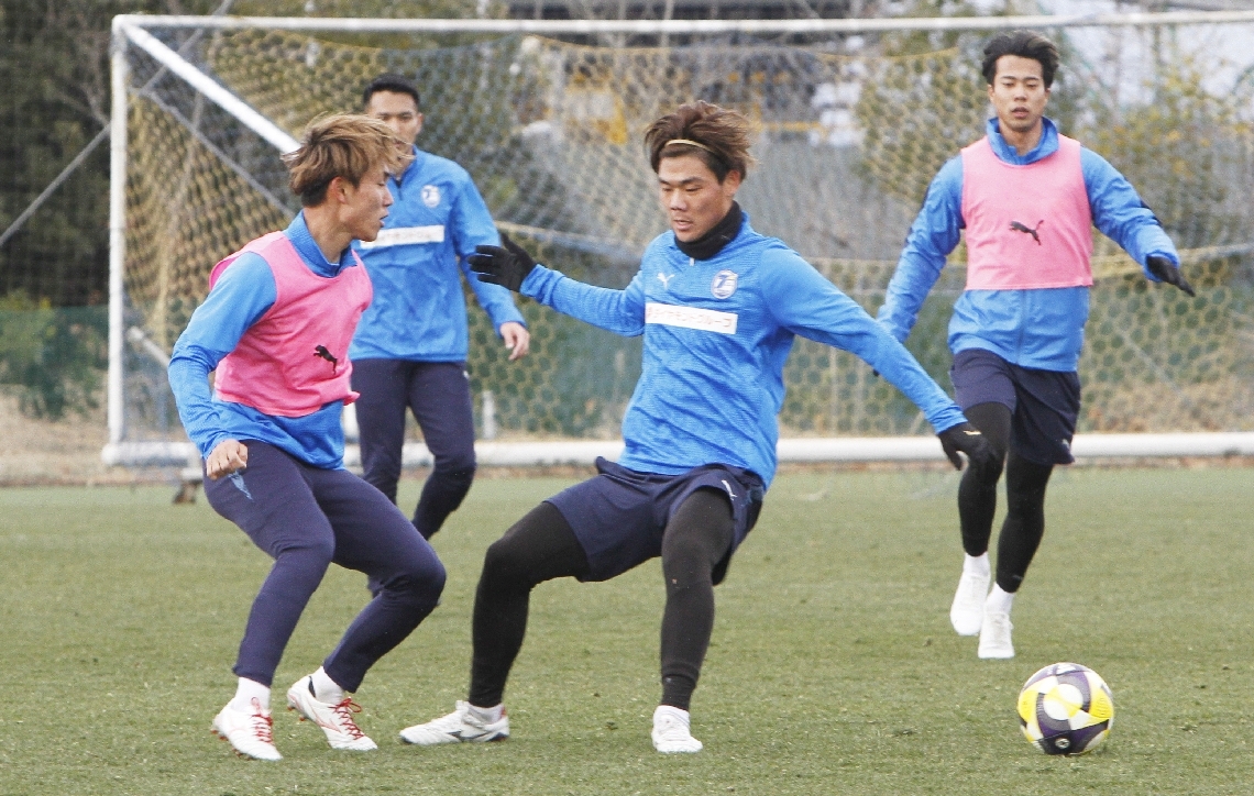 開幕戦に向けて調整する大分の選手たち＝県サッカー協会スポーツ公園