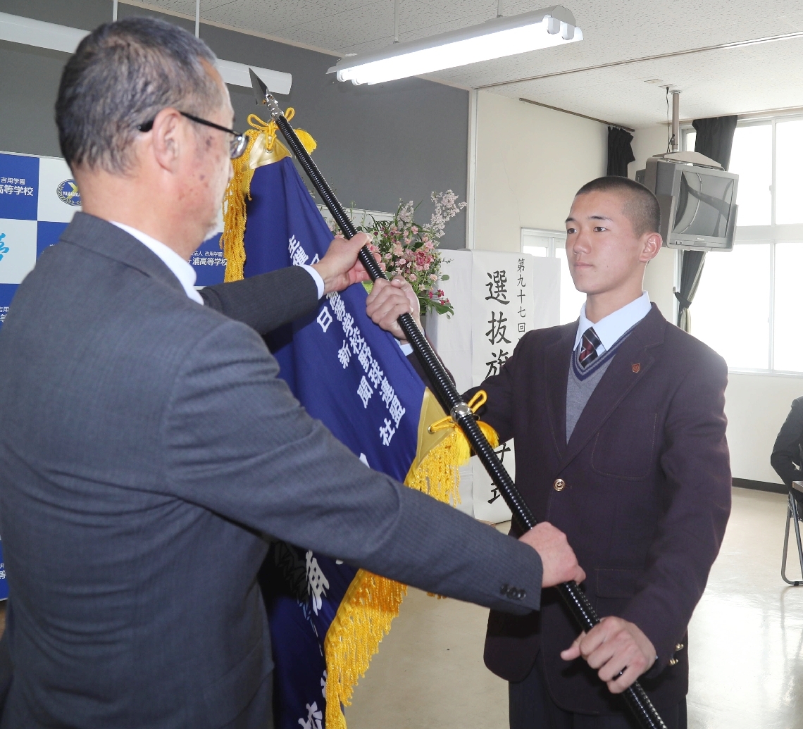 小幡校長（左）から選抜旗を受け取る田原主将＝柳ケ浦高