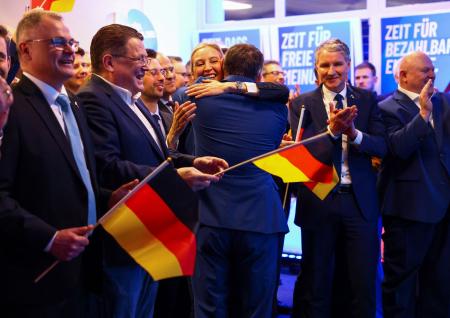 選挙結果に抱き合って喜ぶ「ドイツのための選択肢（ＡｆＤ）」のワイデル（中央）、クルパラ両共同代表＝２３日、ベルリン（ロイター＝共同）