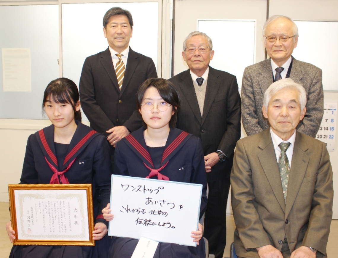 別府市退職校長会から表彰状を受け取った北部中の山本きららさん（前列中央）と田中柚羽さん（同左）＝北部中