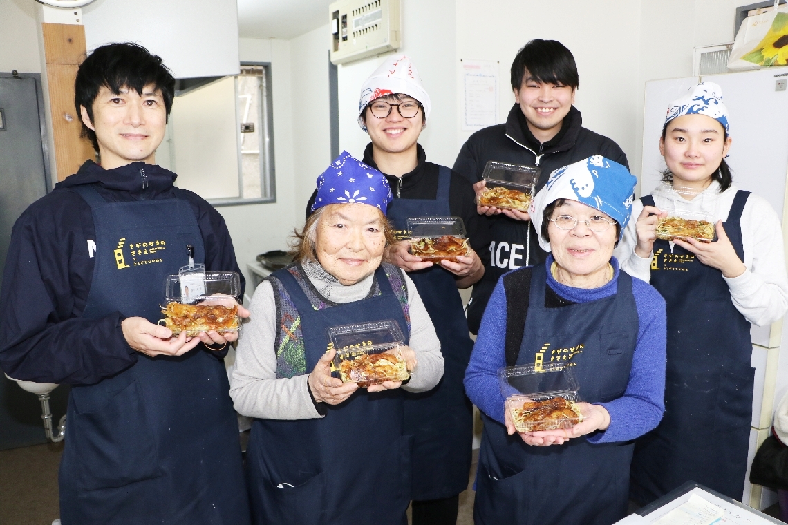 うす焼きを手に１周年を喜ぶ、佐賀関ふれあいカフェのスタッフ＝大分市佐賀関