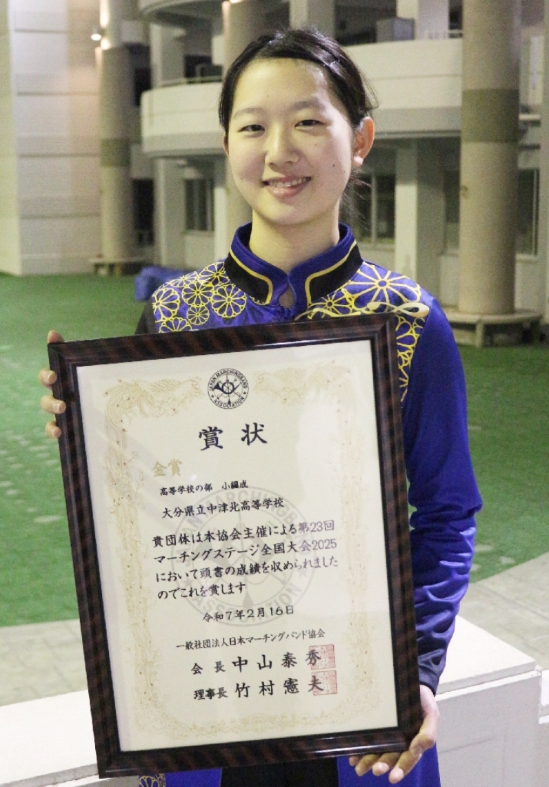 金賞の賞状を持つ吹奏楽部の江藤光華部長