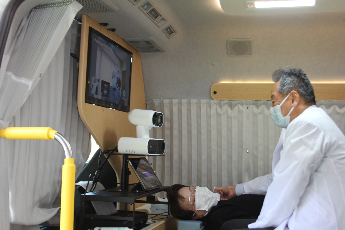 車内で検査を受ける患者。モニターの小野院長が問診して診断する＝杵築市熊野