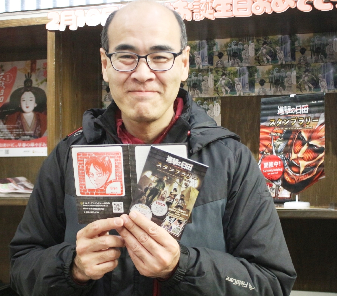 「進撃の巨人」とコラボした市内スポットを巡るスタンプラリーを開催している市観光協会の武内雅宣さん＝日田市元町の市観光協会