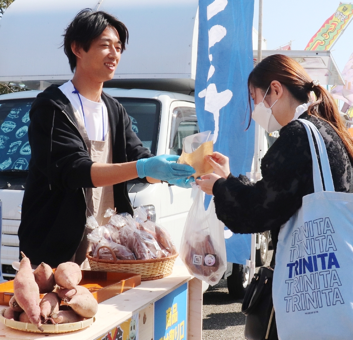 育てたサツマイモの焼き芋などを販売する松本怜さん（左）＝大分市横尾