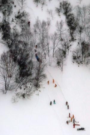 高校生らが雪崩に巻き込まれたスキー場周辺で、救助活動をする消防隊員ら＝２０１７年３月２７日、栃木県那須町