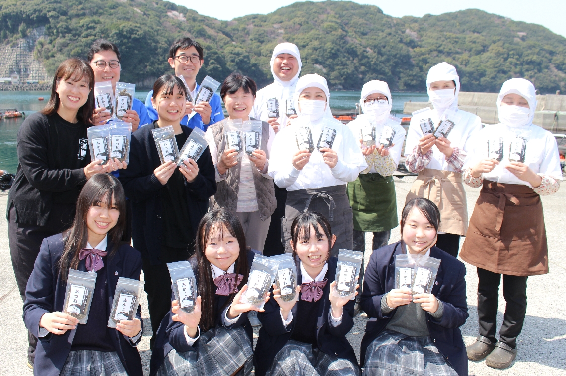 出来上がった２種のふりかけを手にする生徒と山忠、めばるの関係者ら＝佐伯市鶴見沖松浦の漁村女性グループめばる前