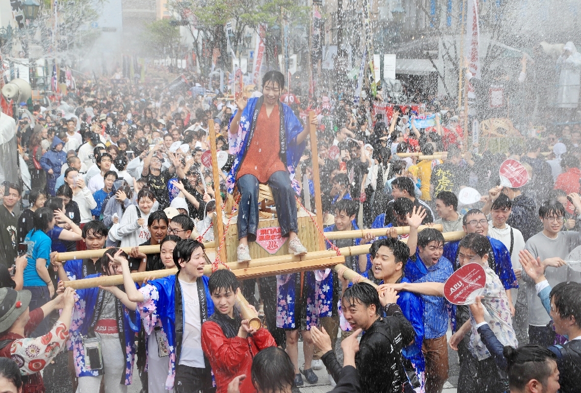２０２４年の「湯ぶっかけまつり」。大量の温泉を浴びながら練り歩くみこし＝別府市の別府駅前通り