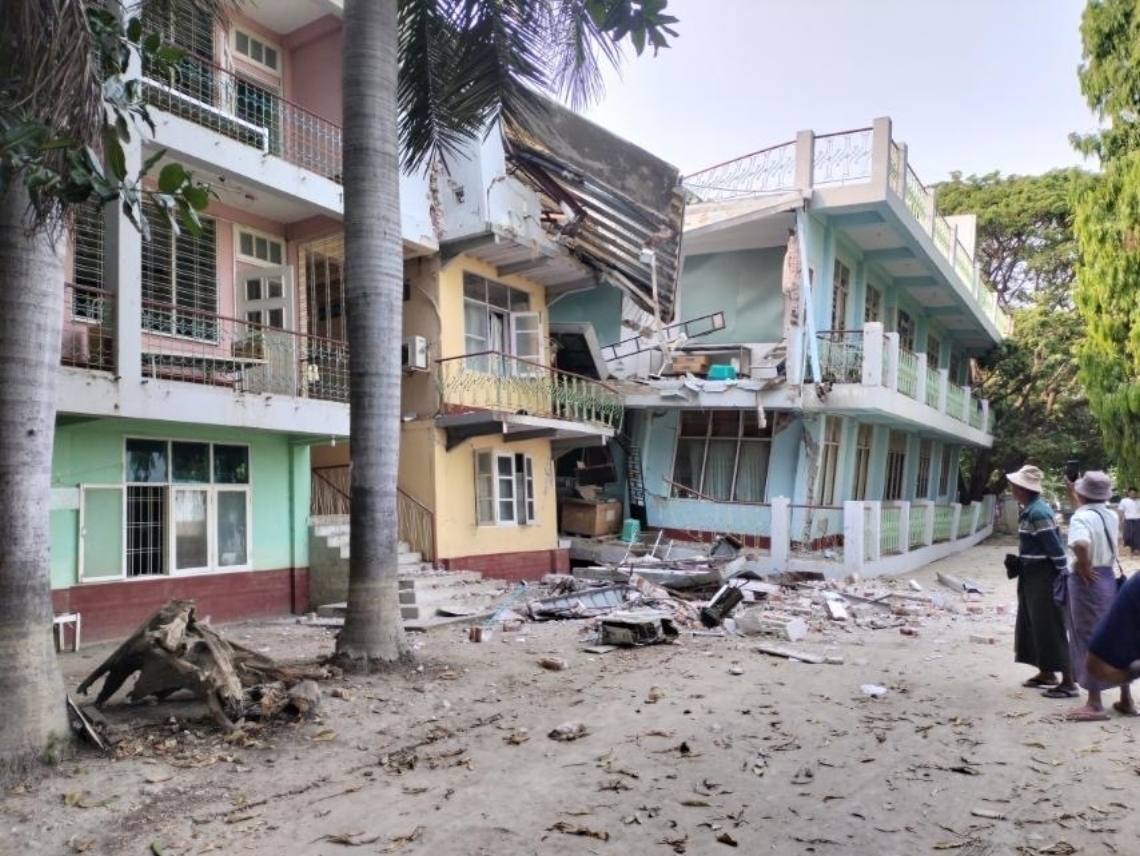 ミャンマーを襲った大地震で、１階部分がつぶれたワッチェ慈善病院（右奥）＝３月２８日（ジャパンハート提供）