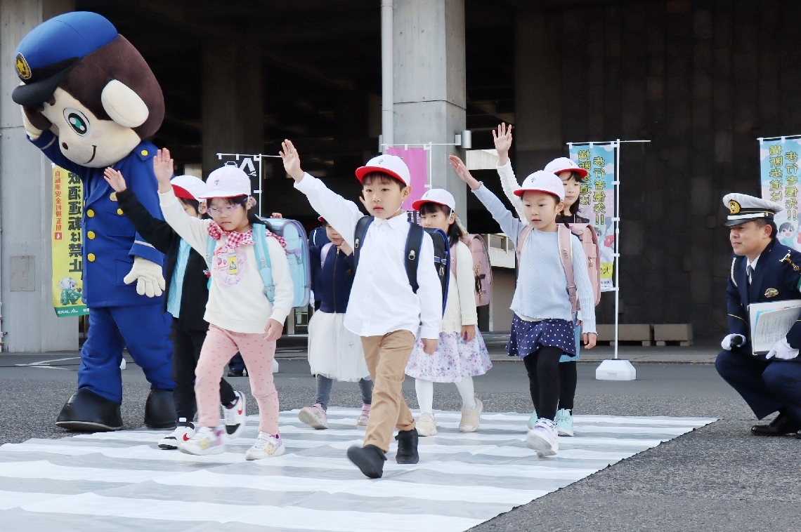 横断歩道の正しい渡り方を披露する小学生＝４日、県庁
