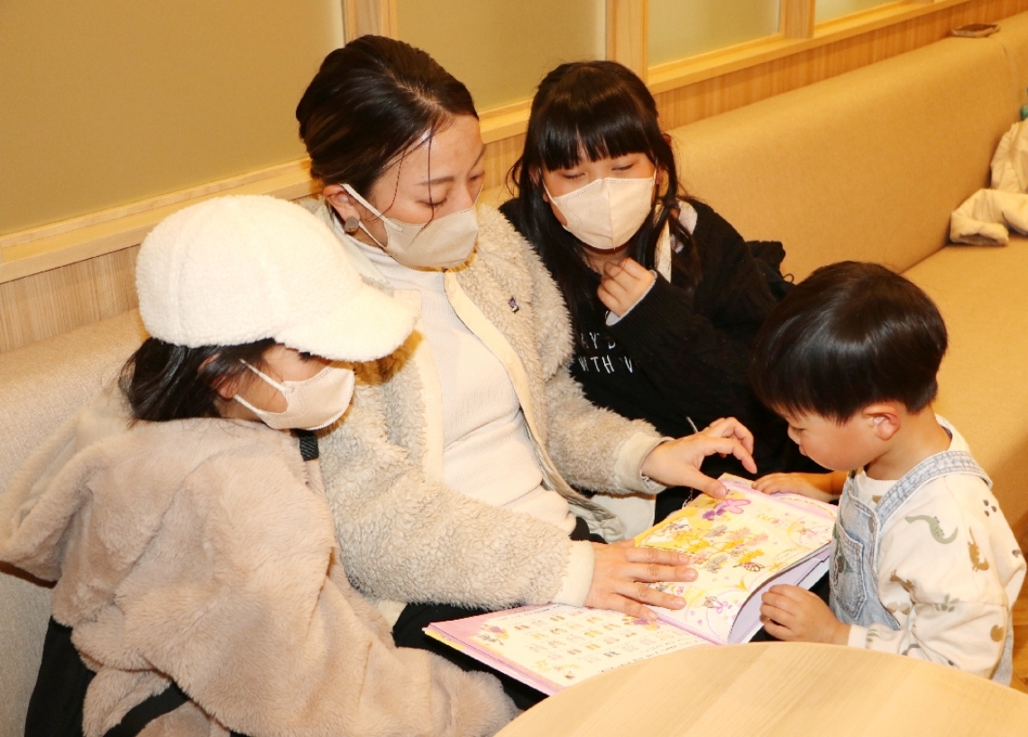 院内に設けられた出張本屋で選んだ本を読む親子連れ