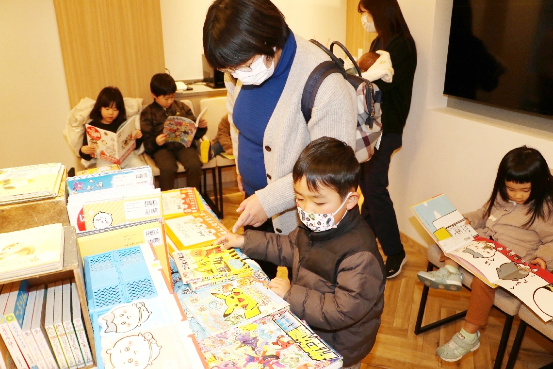 院内に設けられた出張本屋で本を選ぶ親子連れ