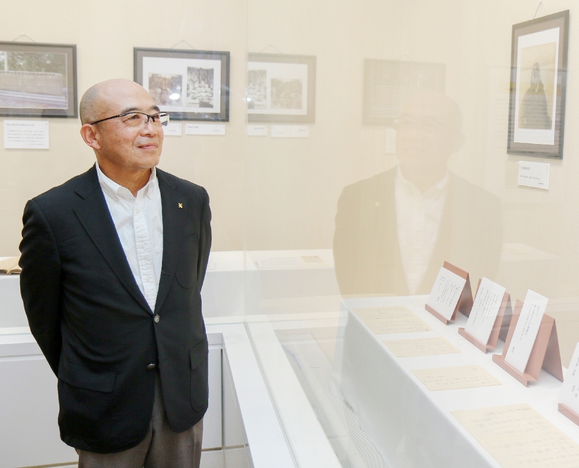 伯父の藤井真治大尉の写真や遺書を眺める藤井昭芳さん＝３月２８日、宇佐市民図書館