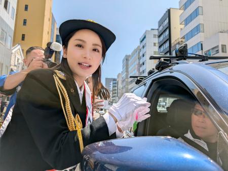 ドライバーに交通安全祈願の折り鶴を手渡す俳優の平祐奈さん＝９日午前、東京都中央区