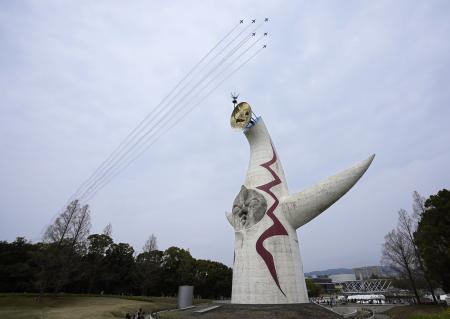 １９７０年大阪万博のシンボル「太陽の塔」の上空を予行飛行するブルーインパルス＝１０日、大阪府吹田市の万博記念公園