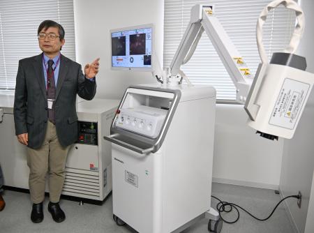 「がん光免疫療法」の臨床研究で使用される専用カメラがついたレーザー機器＝１５日午後、大阪府枚方市