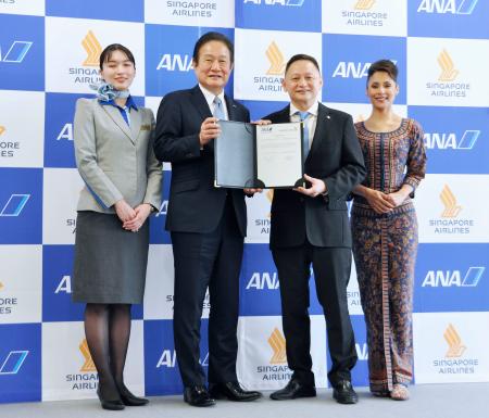 契約書を持つ全日空の井上慎一社長（中央左）とシンガポール航空のゴー・チュン・ポンＣＥＯ（同右）＝１７日午後、東京都大田区