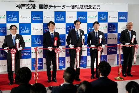 国際チャーター便の就航記念式典で、テープカットする神戸市の久元喜造市長（中央）ら＝１８日午前、神戸空港